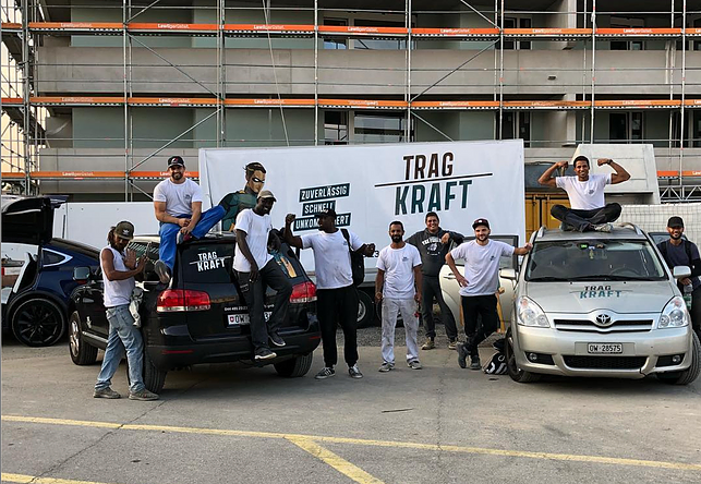 Tragkraft Team vor Firmenfahrzeugen